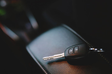 Close up of a car key ring and remote control alarm system charm in vehicle new car interior. soft...