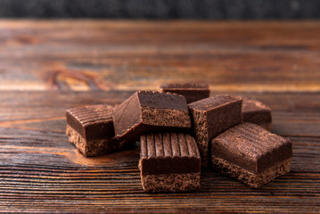 Chocolate toffees on dark wooden background.