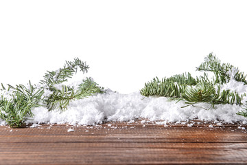 Cold snow with fir tree branches on wooden table against white background