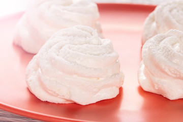 Homemade white marshmallow on an orange plate on an old wooden table in the kitchen.