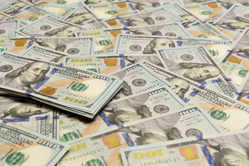 A pile of one hundred US banknotes with president portraits. Cash of hundred dollar bills, dollar background image with high resolution.