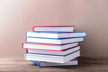 Many books on table against color background