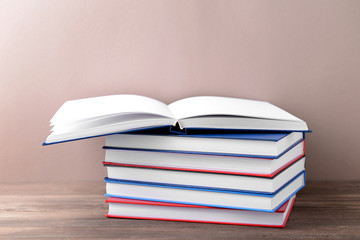 Many books on table against color background