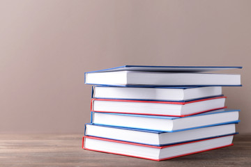 Many books on table against color background