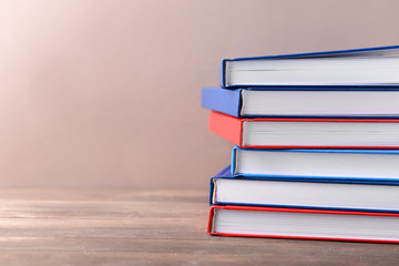 Many books on table against color background