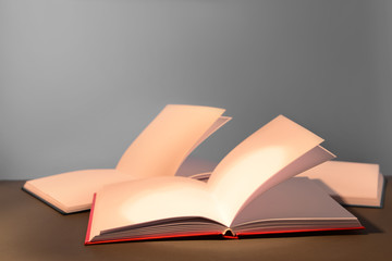 Open books on table against grey background