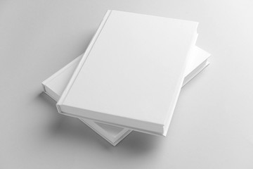 Books with blank covers on light background