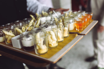 Waiter carries dish with snacks walking to the backyard