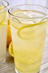 Two glasses of lemonade on a wooden surface