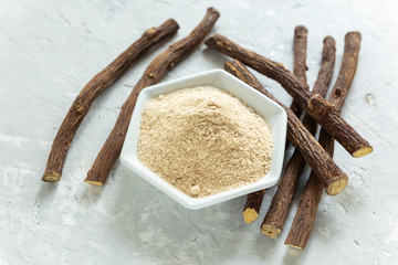 Powder and licorice root on the table - Glycyrrhiza glabra