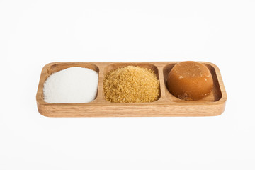 white sugar, brown sugar and sugar cane panela on white background