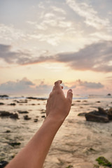 Girl reaches out to the clouds. Girl pulls her hand to the sea.