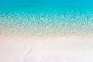 Fototapeten Welle des Meeres am Sandstrand. Tropischer Strand mit blauem Himmel und klarem Meer. © Yingyaipumi