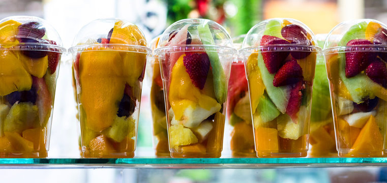 Fruit salad in plastic cups takeaway. Sliced organic fruits and berries, healthy snack to go, copy s