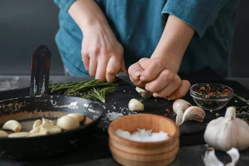 Foto op Canvas Woman cutting fresh garlic at table © Pixel-Shot