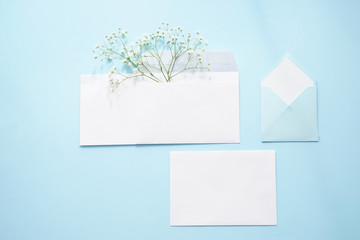 Paper envelopes with flowers on color background