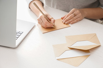 Young woman writing letter at table
