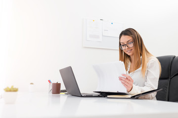 Beautiful young owner girl working in her office.