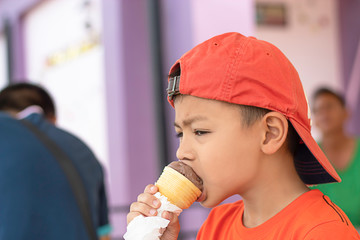 The boy holding the ice cream eating