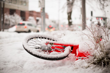 Red Bike covered in snow laying on ground