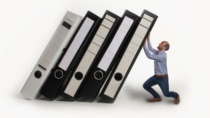 Mann stemmt sich gegen schwere Aktenordner