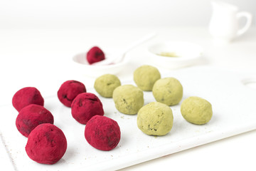 Selective focus on matcha green tea and pink raspberry beetroot truffles