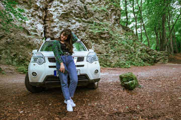 woman standing near white suv car in forest