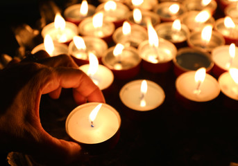 candles in the church and the hand of old lady after the funeral
