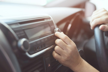 close up hand open car radio listening. Car Driver changing turning button Radio Stations on His Vehicle Multimedia System. Modern touch screen Audio stereo System. transportation and vehicle concept - obrazy, fototapety, plakaty