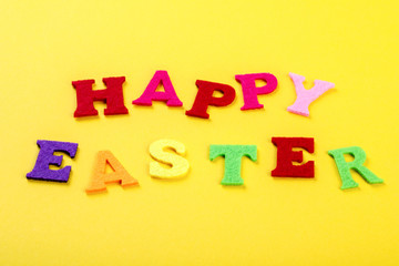 Easter concept. Inscription in colored letters Happy Easter on a yellow background.Top View. Flat Lay.Copy space for Text