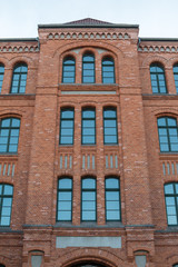 Fototapeta premium Fasada starego domu murowanego z pięknymi i dużymi oknami