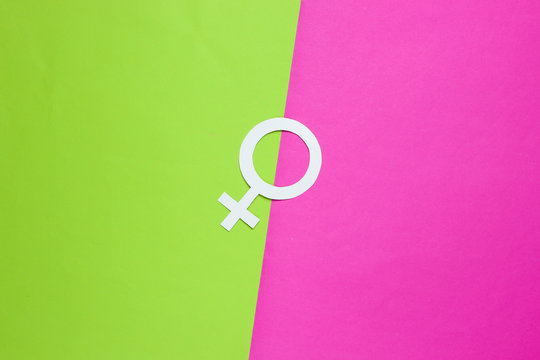 Woman gender symbol on green pink background. Top view. Minimalism. Gender equality