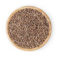Dried coriander seeds in wooden bowl isolated on white background with clipping path