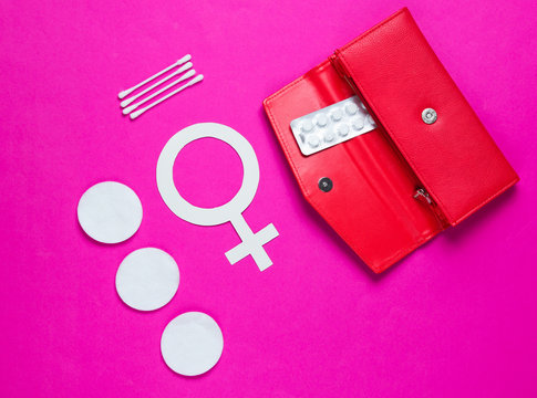 Women Health. Products for feminine hygiene, self-care, female gender symbol on pink background. Ear sticks, pads, pills in purse. Top view