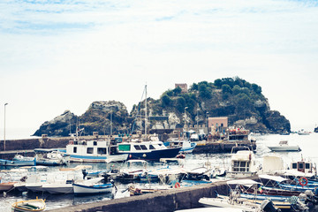 Fototapeta na wymiar Acitrezza harbor with fisher boats next to Cyclops islands, Catania, Sicily