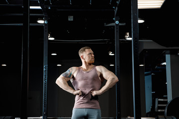 Strong man posing in gym