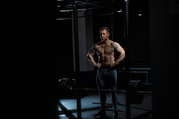 Fototapeta na wymiar Strong man posing in gym