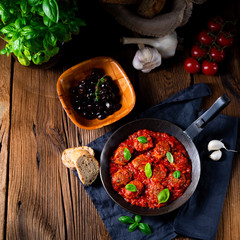Baked mini meatballs in tomato sauce with basil
