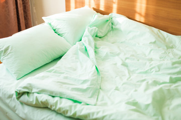 Fototapeta na wymiar Minty green bedding on the bed at the early morning
