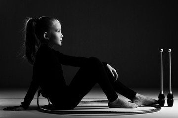 Teenager girl involved in rhythmic gymnastics. Black background