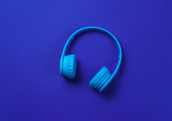 Wireless headphones on dark blue background. Top view.
