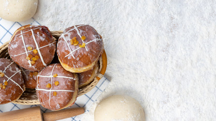Tasty doughnuts with jam on flour background. Fat Thursday decoration.
