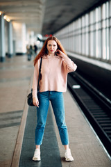 Positive redhead young female in subway portrait