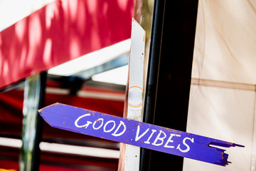 Panneau flèche avec inscription good vibes devant un restaurant