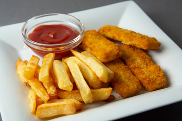 Closeup fish and chips with french fries - unhealthy food, grey backgrpound.