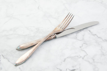 Vintage knife and fork on white gray background.