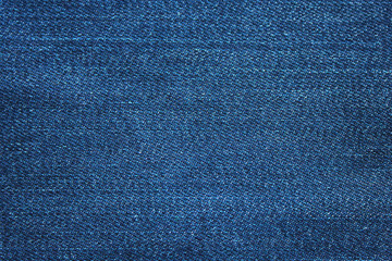 Navy blue dark jeans denim fabric texture background. Classic blue jean cloth empty canvas,...