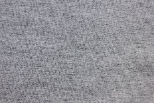 Gray fabric texture background of light material design. Grey cloth pattern of hoodie, sweater, pullover or shirt, casual empty clothing. Close up top view of grey backdrop with empty copy space