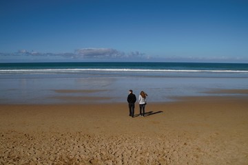 Couple walks at the shoreline in Australia