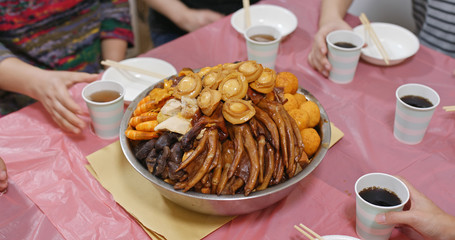 Traditional Chinese family eating big bowl feast together at home